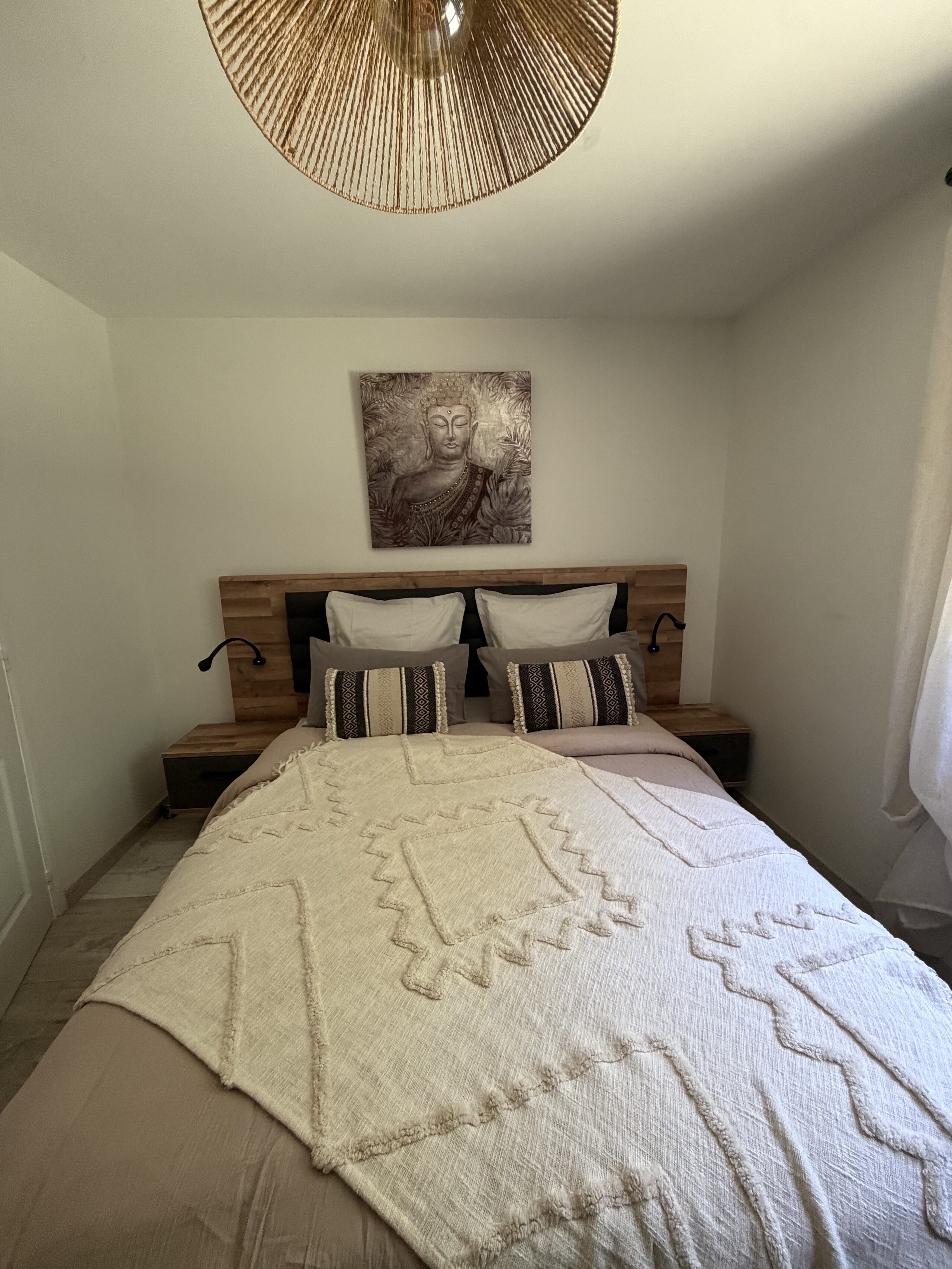 La chambre parentale, son lit double et sa suspension en rotin