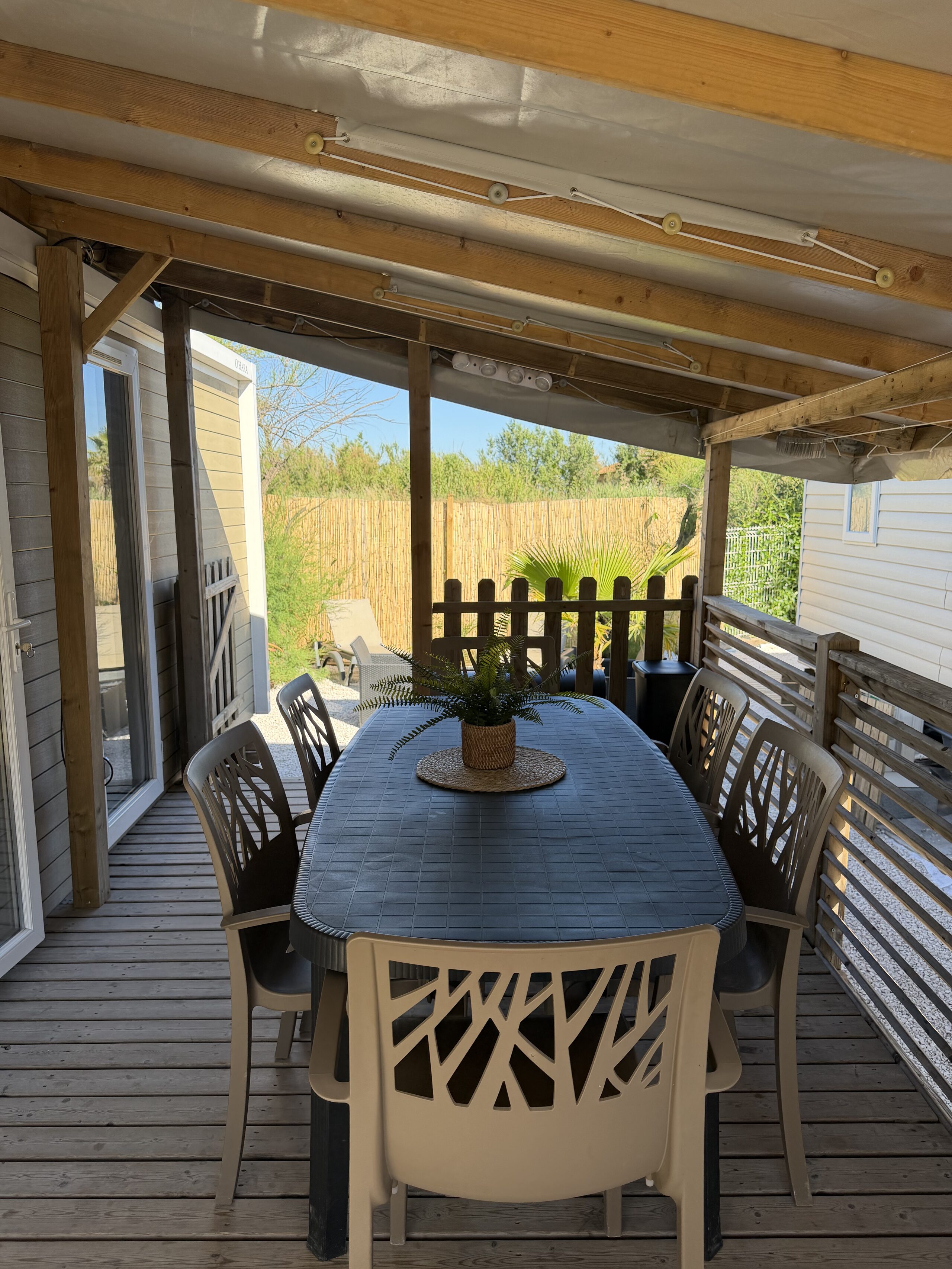 La grande table à manger, à l'ombre de la terrasse couverte